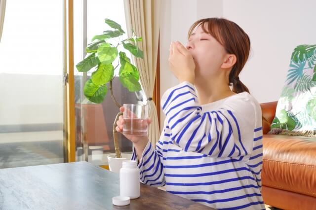 薬を飲む女性